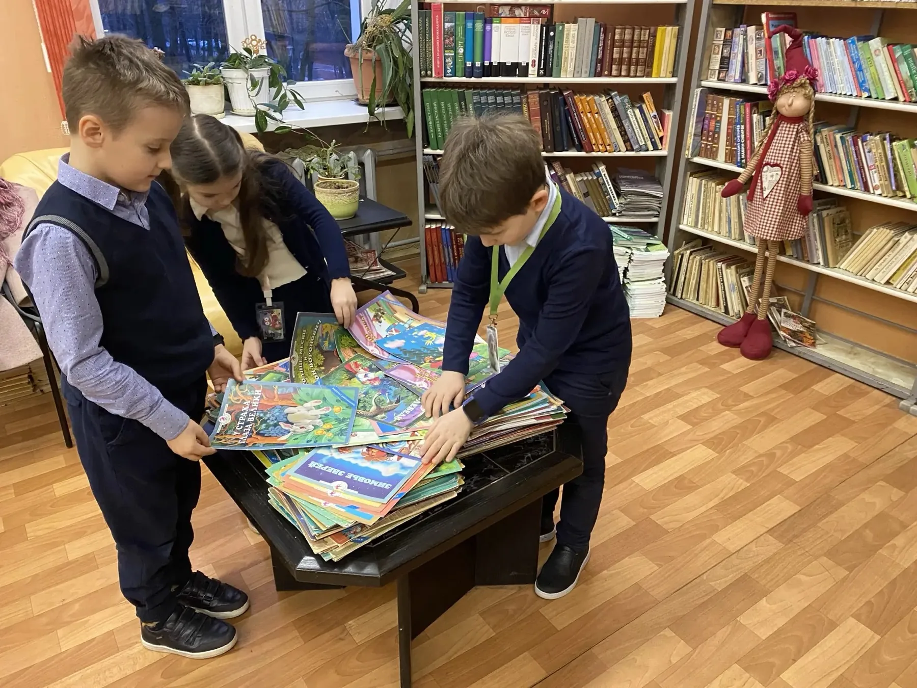 Ребята выбирают книги в библиотеке